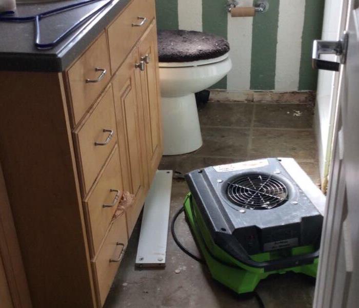 an air mover in a bathroom with no flooring
